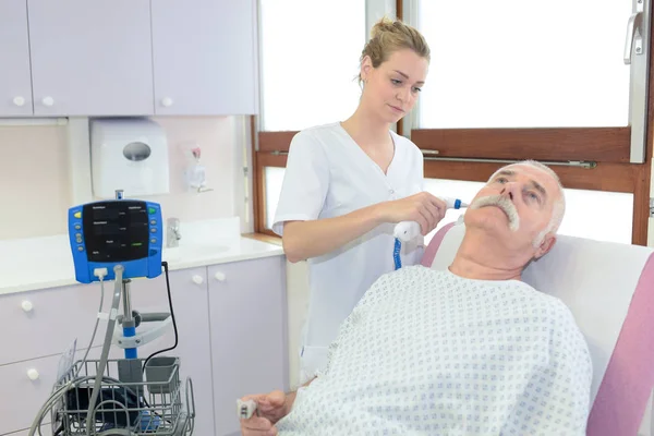 Arzt hält Otoskop in der Hand und untersucht Ohr des Seniors — Stockfoto