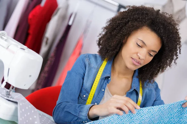 Fashion designer cutting fabric on dressmaking table — Stock Photo, Image