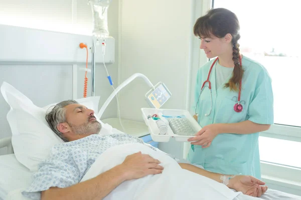 Patient receiving medicine from female nurse — Stock Photo, Image