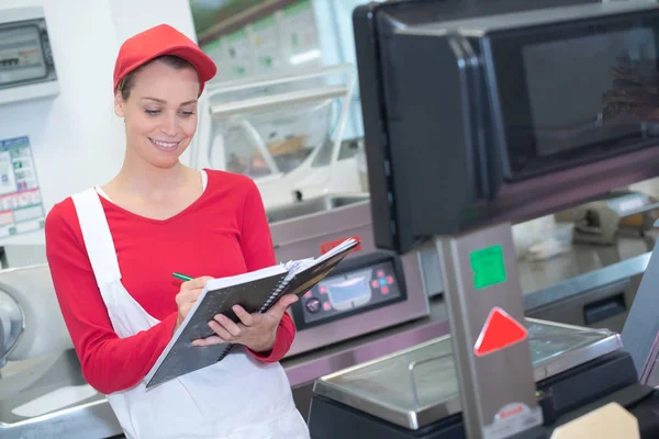 Glad försäljare väger kött på stormarknaden — Stockfoto