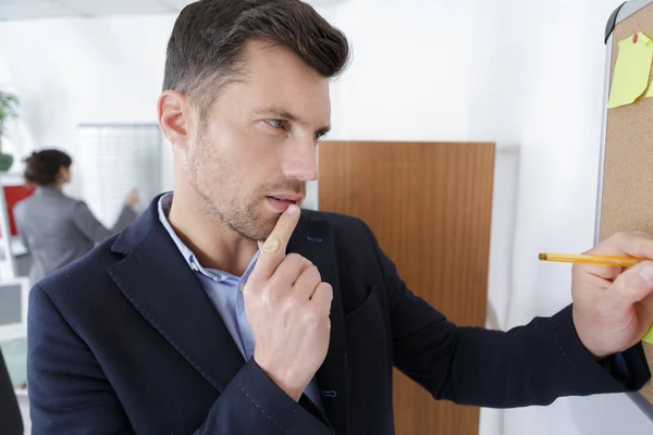 Jefe mirando notas adhesivas en el tablero de la oficina — Foto de Stock