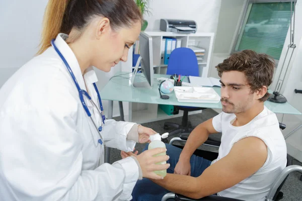 Physiothérapeute injectant un patient de sexe masculin en clinique — Photo