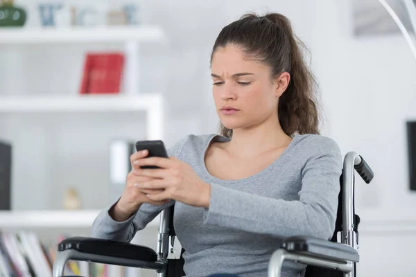 Pewnie kobieta na wózku inwalidzkim z jej telefonu komórkowego — Zdjęcie stockowe