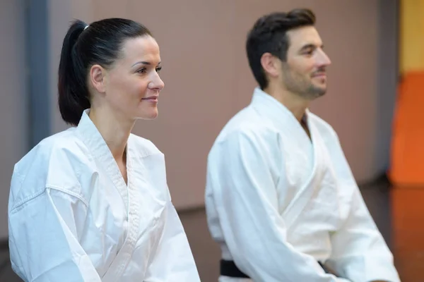 Mannelijke en vrouwelijke karatekas tijdens de les — Stockfoto