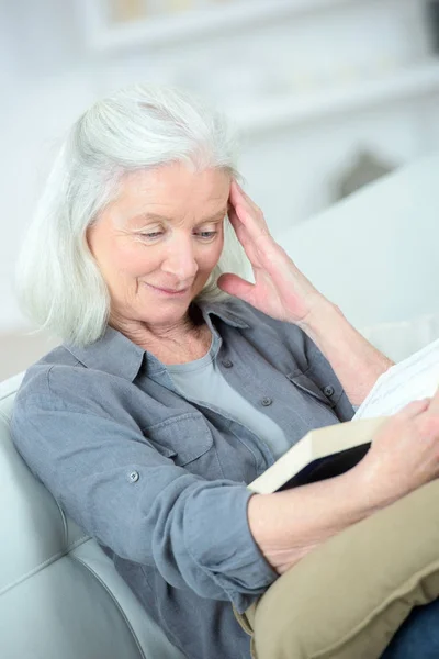 Ηλικιωμένη γυναίκα διαβάζοντας το βιβλίο στο σπίτι — Φωτογραφία Αρχείου