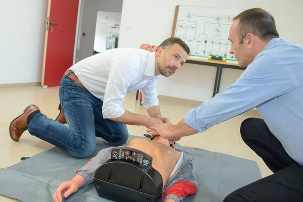 Rescuer teaching a man how to proceed during a traineeship — Stock Photo, Image
