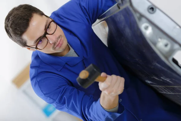 Auto reparatie werknemer plat metalen lichaam auto met behulp van een hamer — Stockfoto