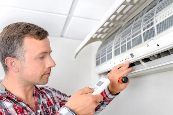 Homem verificando unidade de ar condicionado — Fotografia de Stock