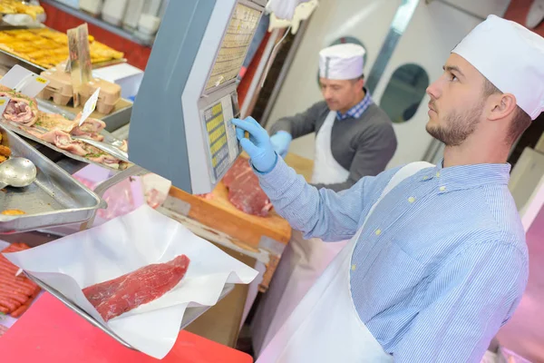 Slager leerling met een gewicht van vlees — Stockfoto