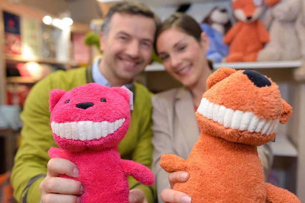 Parents-to-be shopping choosing plush for their kid — Stock Photo, Image