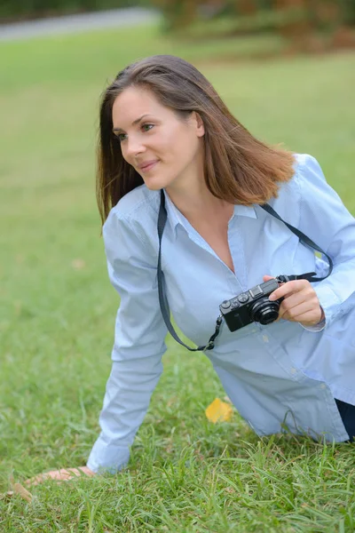 Kadınla çimenlerin üzerinde fotoğraf makinesi ile oturdu. — Stok fotoğraf