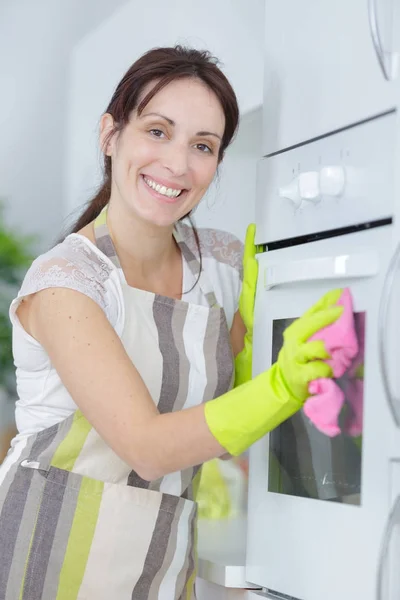 Šťastná dáma čištění trouby — Stock fotografie