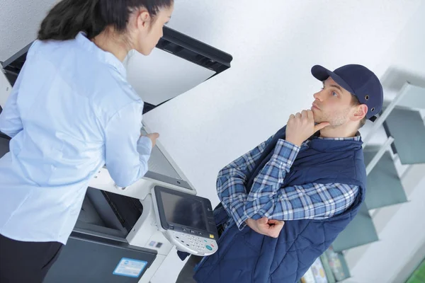 Office worker and contractor in discussion by photocopy machine — Stock Photo, Image