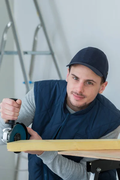 Carpintero guapo usando amoladora en tablón — Foto de Stock