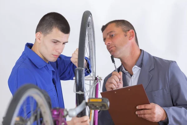 若い男の修理自転車の車輪 — ストック写真