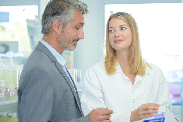 Female pharmacist assisting a client — Stock Photo, Image