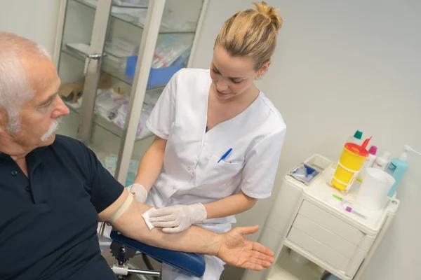 Enfermera tomando la muestra de sangre del hombre de edad avanzada — Foto de Stock