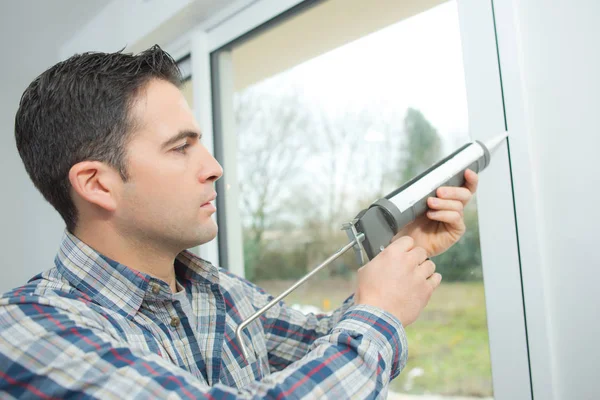 man installing window in house