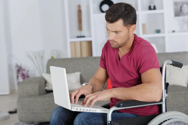 Uomo handicappato utilizzando un computer portatile — Foto Stock