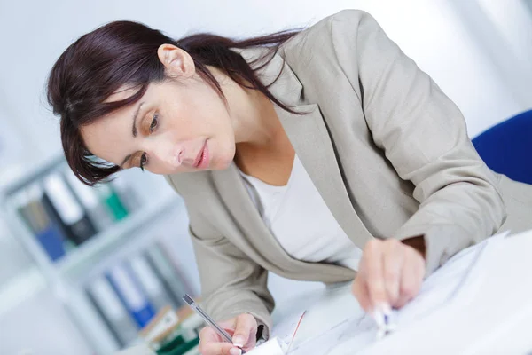 Retrato de una arquitecta con planos en el escritorio en la oficina —  Fotos de Stock