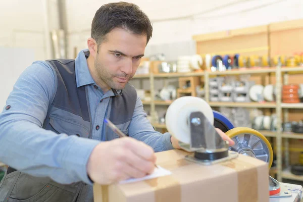 Hombre escribir etiqueta para caja de cartón — Foto de Stock