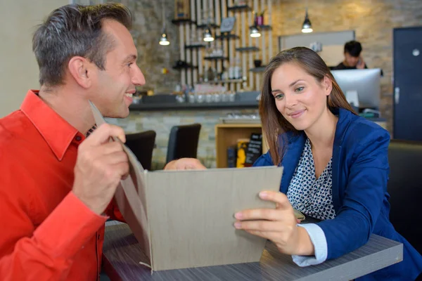 Happy couple choosing from menu in restaurant — Stock Photo, Image