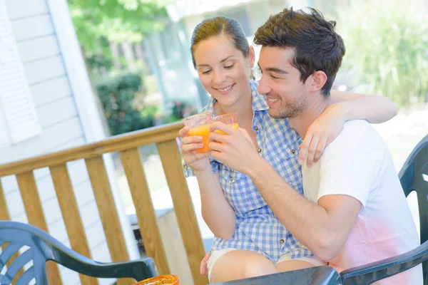 Paar stößt mit Orangensaft an — Stockfoto