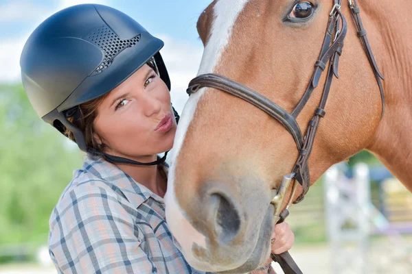 Молода леді цілує голову коня — стокове фото