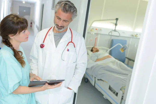 Усміхнений лікар і медсестра з буфера в лікарні — стокове фото