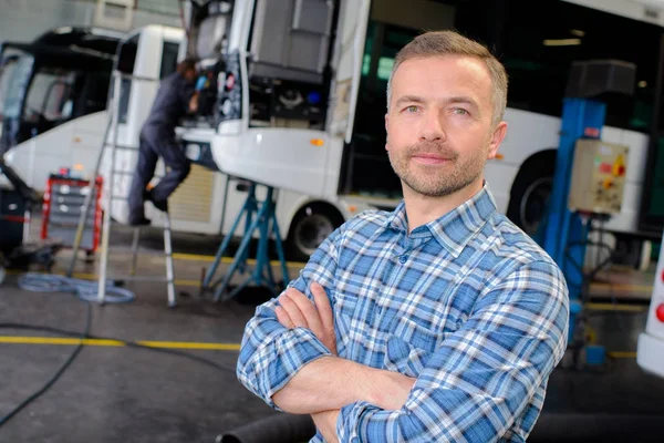 Gerente de garagem posando e veículo — Fotografia de Stock