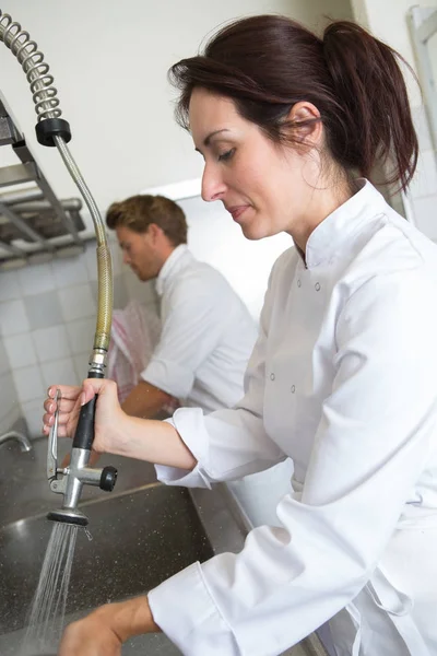 Female employee washing dishes at the restaurant — Stock Photo, Image