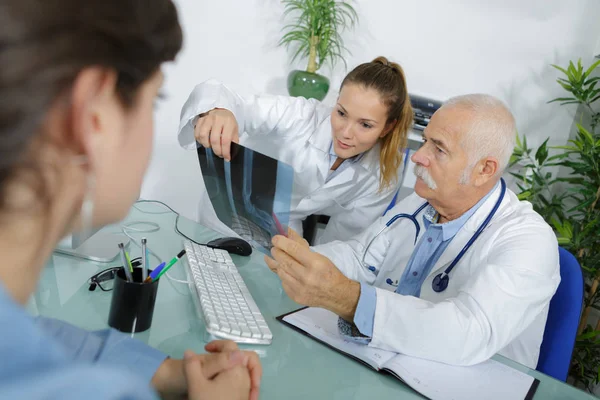 Zwei medizinische Mitarbeiter betrachten Röntgenbild — Stockfoto