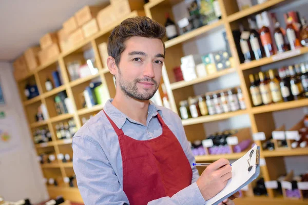 Salesman taking inventory in wine shop — Stock Photo, Image