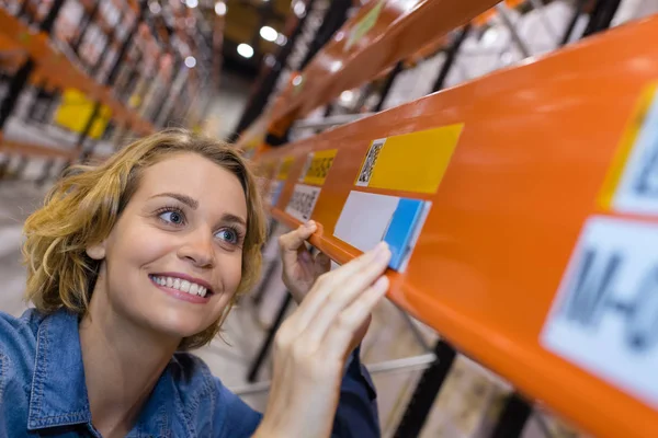 Trabajador de almacén feliz poniendo precios en los estantes — Foto de Stock