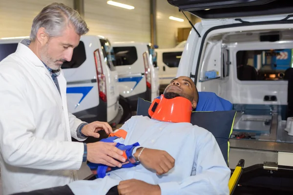Muž s krční límec na otevřených dveří ambulance — Stock fotografie