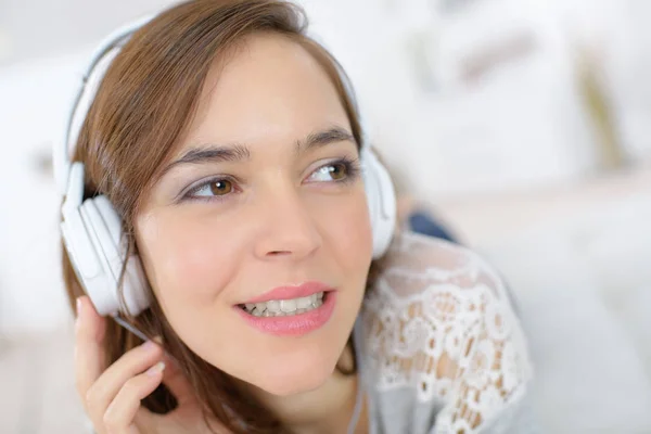 Mujer joven con auriculares escuchando música — Foto de Stock