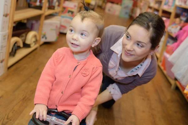 Moeder met dochter in de speelgoedwinkel — Stockfoto