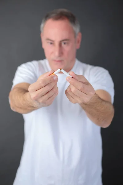 Portrait of mature man breaking cigarette — Stock Photo, Image