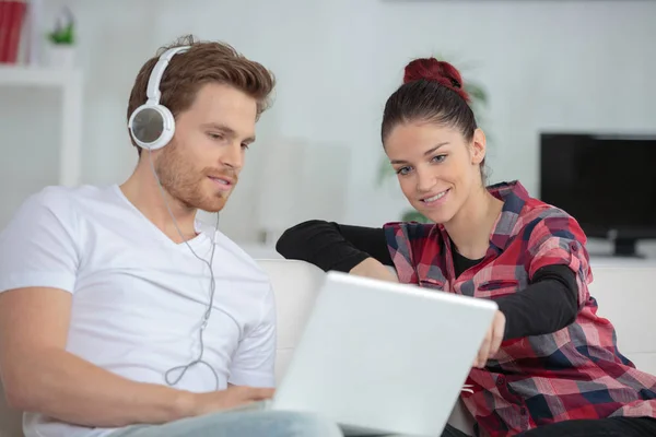 Man showing something to a woman from the laptop — Stock Photo, Image