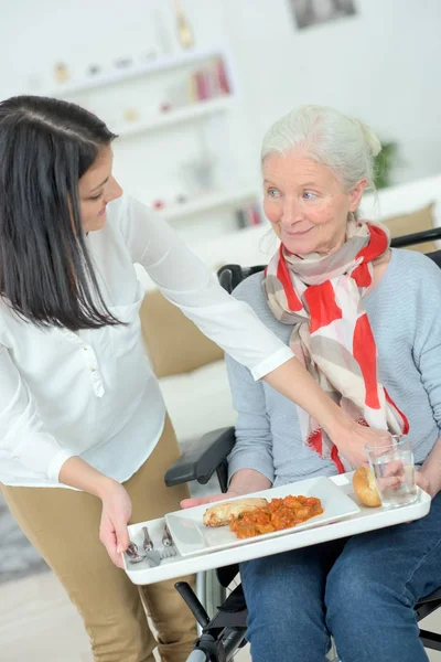 Giving old lady her lunch — Stock Photo, Image