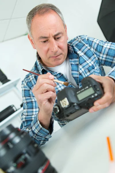 Fırça kullanarak fotoğraf makinesi tamircisi — Stok fotoğraf