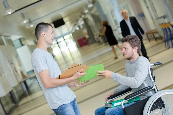 Två tonåringar står i universitet korridoren en är inaktiverad — Stockfoto