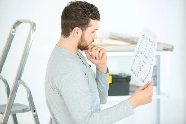 Joven arquitecto masculino leyendo el plano —  Fotos de Stock