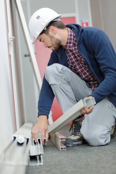 Workman holding pvc frames — Stockfoto