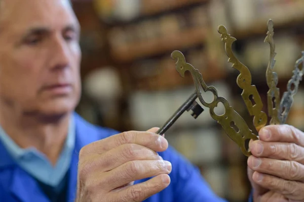 Starszy specjalista z różnymi rodzajami kluczy w ślusarni — Zdjęcie stockowe