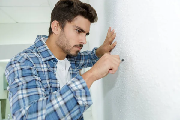 Behörig elektriker förbereder hål innan du installerar apparaten — Stockfoto