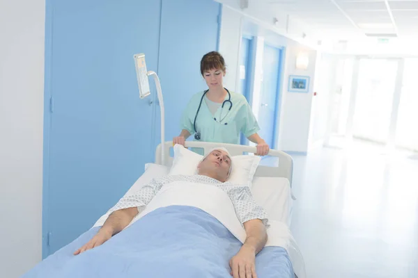 Krankenschwester trägt Mann auf Krankenhausfahrt in den Notfall — Stockfoto