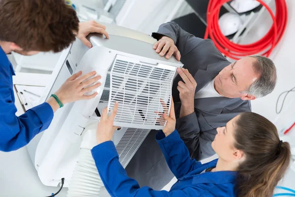 Studenten lernen die Reparatur von Klimaanlagen von einem erfahrenen Lehrer — Stockfoto