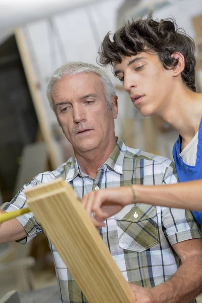 Timmerlieden meten plank van hout — Stockfoto