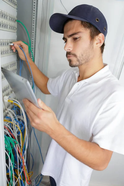 Konzentrierter Elektriker, der Sicherheitsverfahren anwendet, während er an der Schalttafel arbeitet — Stockfoto